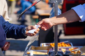 Hands of the shopkeeper who passes the sales receipt to the buyer