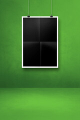 Black folded poster hanging on a green wall with clips