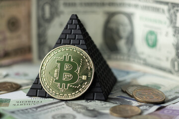 Bitcoin on a background of pyramids and dollars