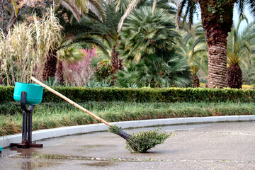homemade broom on the trash can. cleaning of the courtyard in warmer
