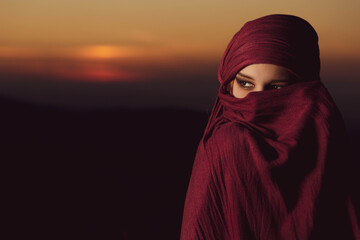 Portrait of a beautiful young Arabic woman with red scarf. Copy space