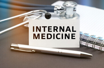On the table is a diary, a stethoscope and a business card with the inscription - INTERNAL MEDICINE