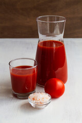 close-up glass of Tomato juice with pink salt. Healthy drink with tomato juice in a glass isolated on a white background with copy space. vertical