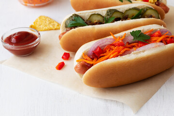 homemade hot dogs with carrot and chips on the white table. tasty Hot dog with pickles, sauce and...