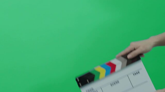 Clapperboard hitting. Movie film slate. close up hand clapping empty film slate on blue or green screen color background. in and out film slate cutting for video production. film or Movie shooting.