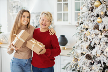 Mother and mature daughter at home. Christmas concept.