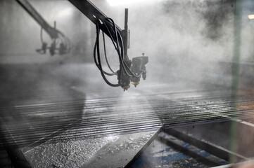 Conveyor for painting large sheets of metal. Lots of paint spray nozzles