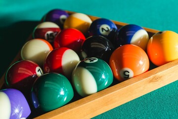 Billiard balls on green table with billiard cue 