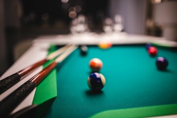 Billiard balls on green table with billiard cue 