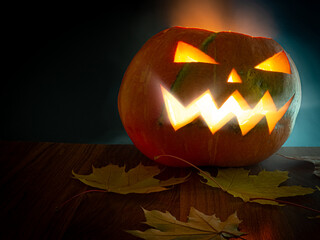 Glowing pumpkin jack-o-lantern on a dark background.