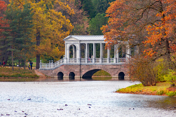 Obraz premium Marble bridge in autumn foliage in Catherine park, Pushkin (Tsarskoe Selo), Saint Petersburg, Russia