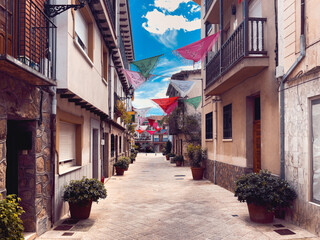 Fototapeta na wymiar Spanish village street in the province of Avila decorated with shawls. Copy space.