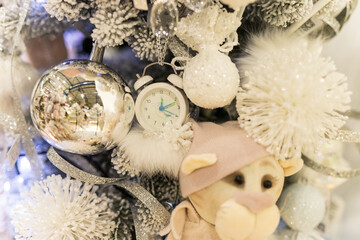 Close up of holidays location with soft toy and garlands on blue white Christmas tree