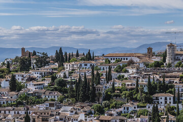 Fototapeta na wymiar Beautiful aerial view city of Granada in a daytime. Granada - capital city of province of Granada, located at foot of Sierra Nevada Mountains. Granada, Andalusia, Spain.