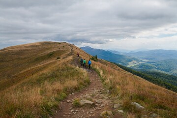 Bieszczady jesienią. Turyści na górskich szlakach. Połoniny. Ciemne chmury. Korory jesieni.