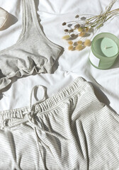 Organic cotton home wear with grey top bra and striped shorts on the white blanket.