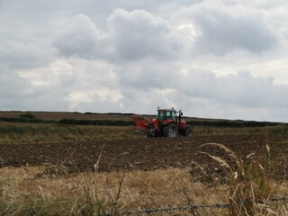 red tractor preparing a filed for planting 