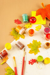 Creative autumn colors composition. Gouache, brushes, paper, traditional decor