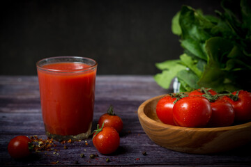 cherry tomatoes and tomato juice on a black background