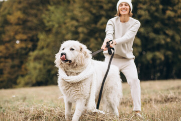 Beautiful woman walking out her dog in a field