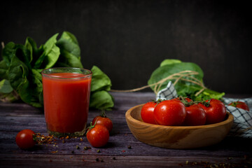 cherry tomatoes and tomato juice on a black background