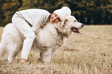 Naklejka premium Beautiful woman walking out her dog in a field