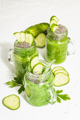 Green smoothie with cucumber in a glass jar. Fresh ripe vegetables, greens, and chia seeds