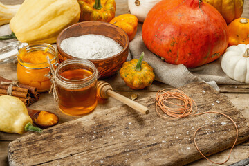 Autumn cooking pastries background. Ripe pumpkin, dough, flour, honey, traditional spices