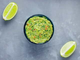 Guacamole bowl on a gray background. Traditional mexican dip sauce guacamole in the bowl. Mexican cuisine. Copy space. Top view