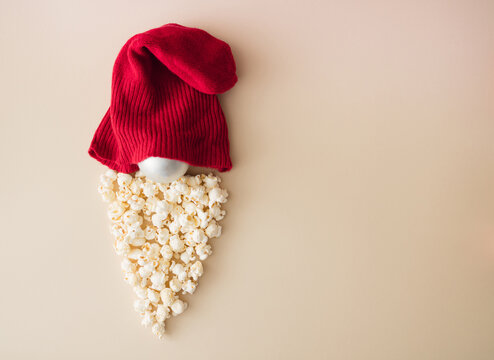 Santa Claus minimal concept. Santas made of popcorn, christmas decoration and red hat. Christmas and New Year background.