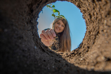 Girl holding tree seedling - planting forest