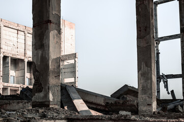 Destroyed concrete large building with concrete debris and remains of the frame. Background.