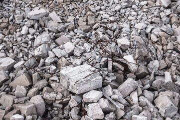 A pile of construction debris in close-up of a concrete block with protruding metal fittings,...