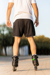Vertical photo of the back of a man skating with inline skates