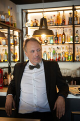 Attractive mature man with tuxedo in a pub