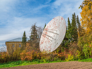 Vintage Radio Telescope, a large satellite dish on a background of observation building and  blue...