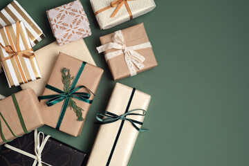 Christmas background with gift boxes over green backdrop. Xmas celebration, preparation for winter...