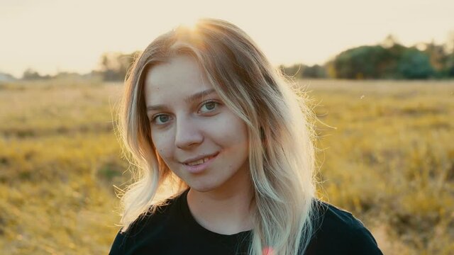 emotional portrait of a beautiful girl with long flowing blonde hair against the background of nature in early autumn at sunset emotions of happiness selective focus..