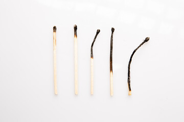 five burnt wooden matches on white background