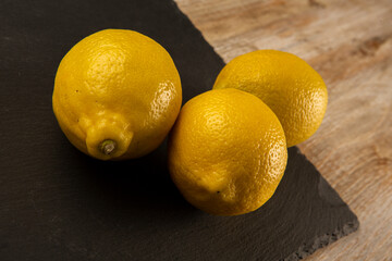 Lemons on slate plate and wooden background
