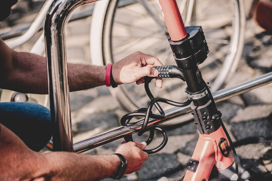 User safely parking electric scooter and locking it to a fence. Eco friendly green modern urban mobility concept of sharing transportation with electric scooters for rent in Ljubljana, Slovenia