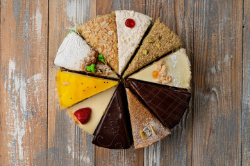 Sampling of different kinds of cake slices on wooden table, top view © Tkachenko Alexey