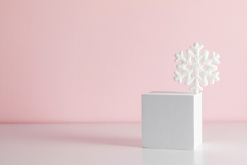 White square podiums and snowflakes in sunlight with shadow on pink background. Winter Christmas showcase.