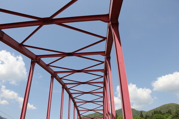 赤く塗装されたトラス橋のある風景