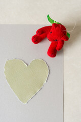 ornamental Christmas bear with torn paper heart viewed from above - with space for copy