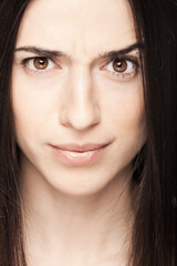 Obraz premium Portrait of a beautiful brunette girl looking at camera with face expression.