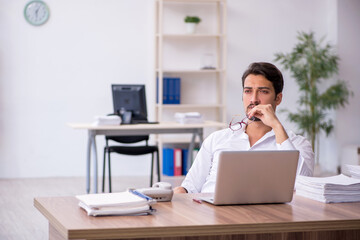 Young male employee and too much work in the office