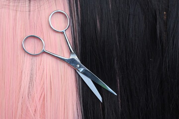 Hair cutting shears on black and pink hair background