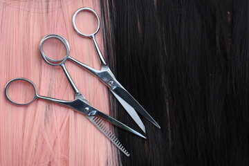 Hair cutting shears on black and pink hair background