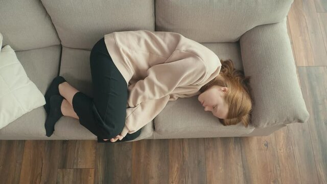View From Above. A Pensive Red-haired Girl is Sad Alone at Home. A Depressed Teenager Suffers From Loneliness, Lack of Communication, Lack of Friends. Mental Health.